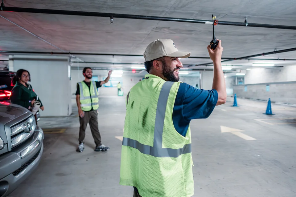 A volunteer in a reflective vest serving in the parking garage.