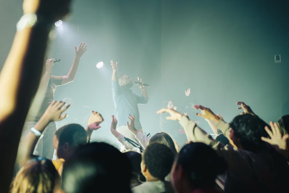 The congregation worshipping with raised hands.